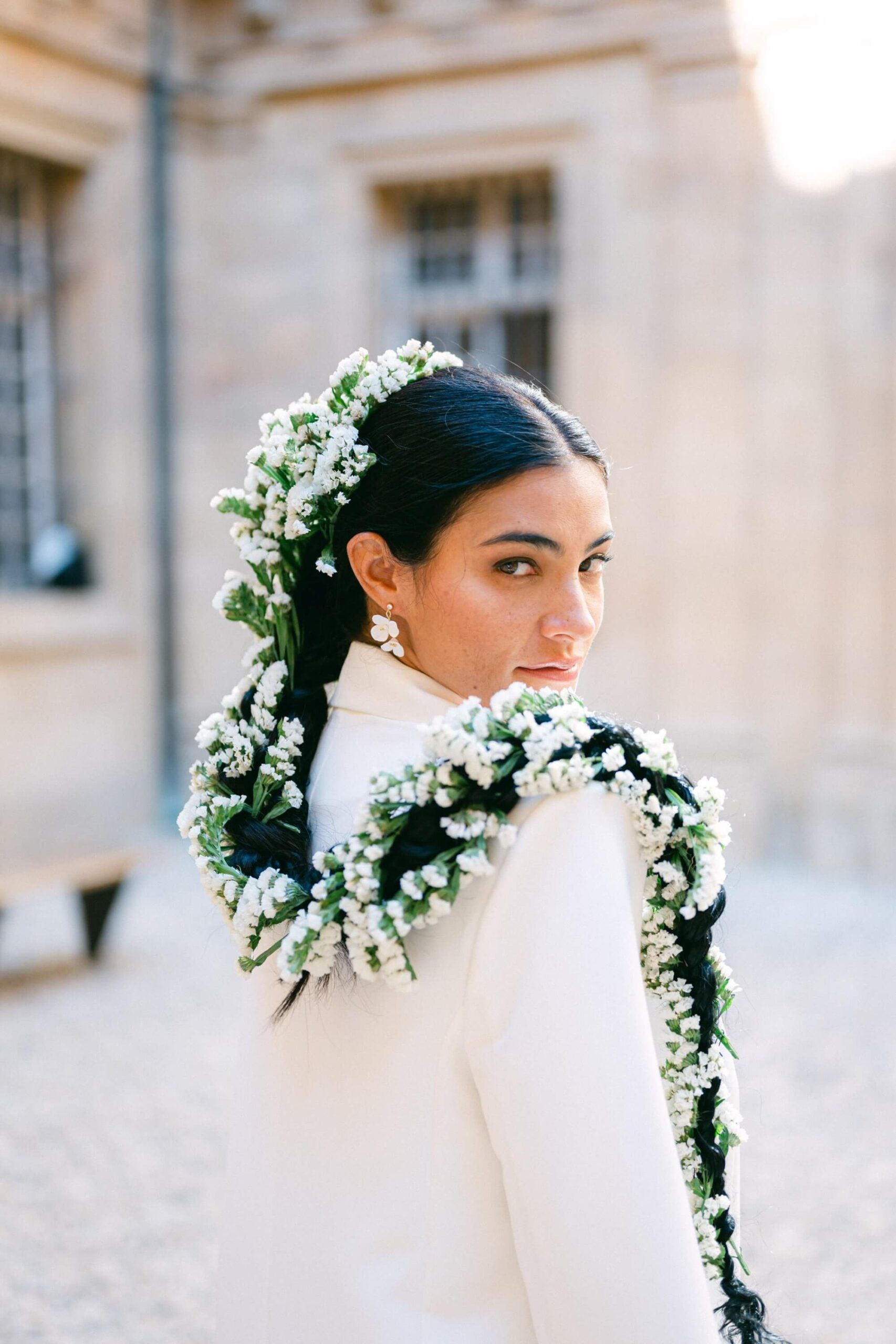 Femme avec fleurs blanches dans les cheveux, costume blanc.