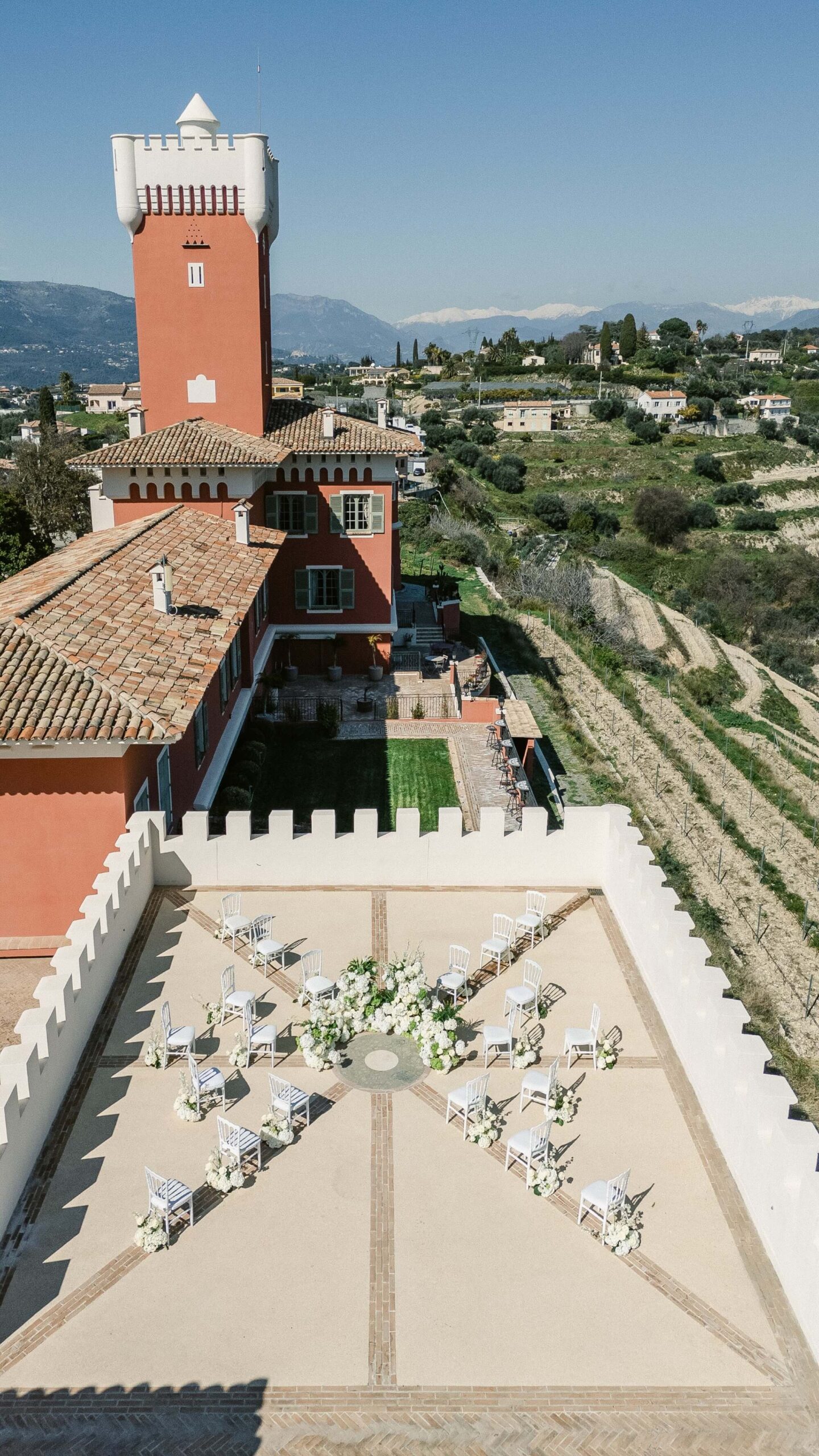 Château avec terrasse et chaises arrangées en cercle.
