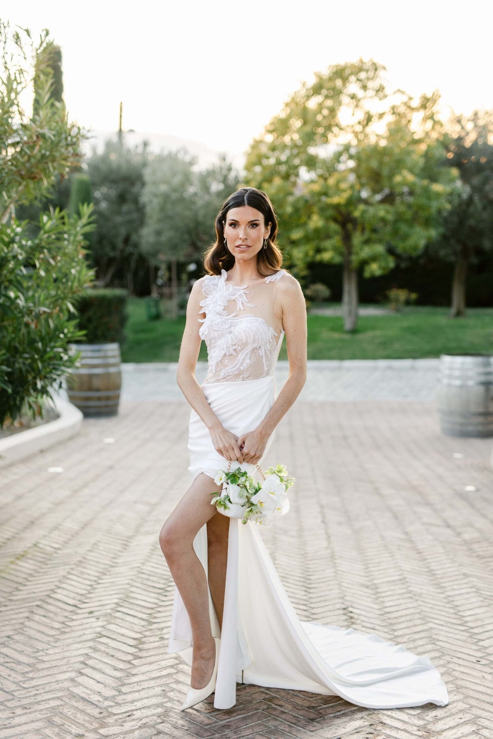 Femme en robe de mariée blanche, bouquet à la main.