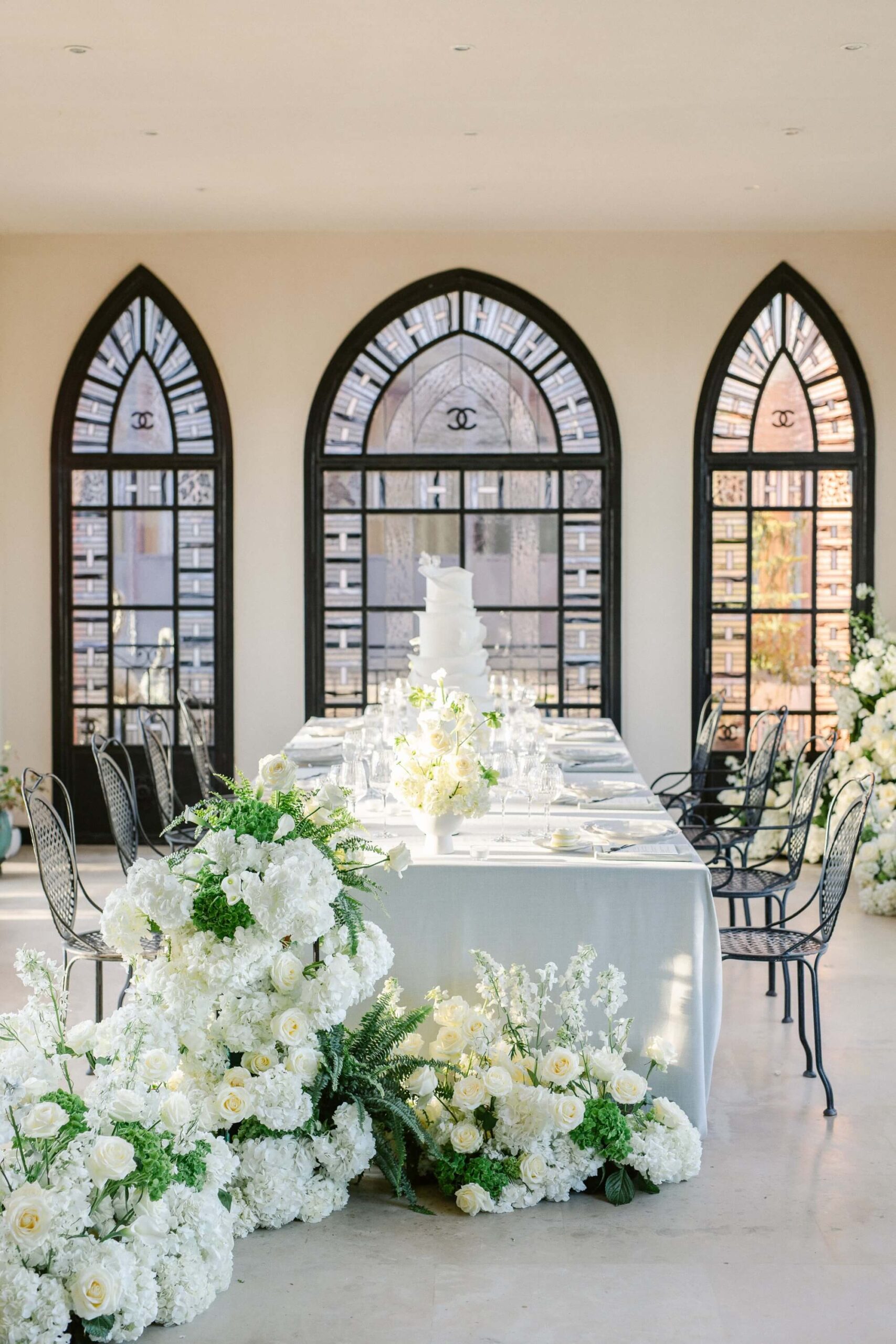 Table de mariage avec fleurs blanches et fenêtres gothiques.